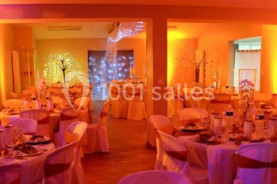 Dortoir avec lits superposés en métal noir, murs rouges et blancs, sol en carrelage foncé, éclairage au plafond.