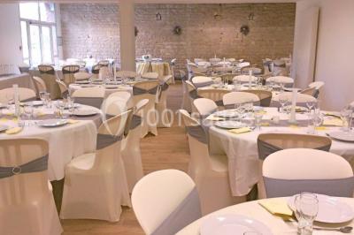 Dortoir avec lits superposés en métal noir, murs rouges et blancs, sol en carrelage foncé, éclairage au plafond.