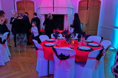 Dortoir avec lits superposés en métal noir, murs rouges et blancs, sol en carrelage foncé, éclairage au plafond.