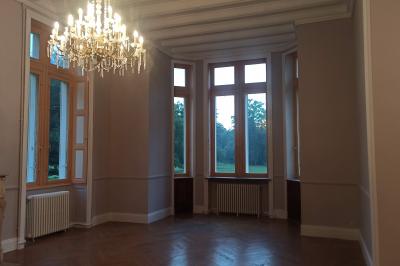 Dortoir avec lits superposés en métal noir, murs rouges et blancs, sol en carrelage foncé, éclairage au plafond.