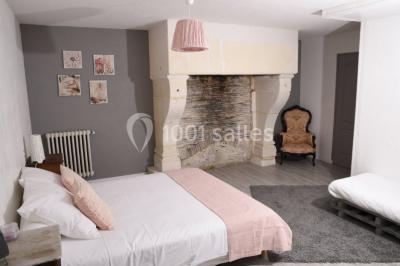 Couronne décorative suspendue sous un plafond en bois, ornée de feuillages, fleurs séchées et éléments naturels.