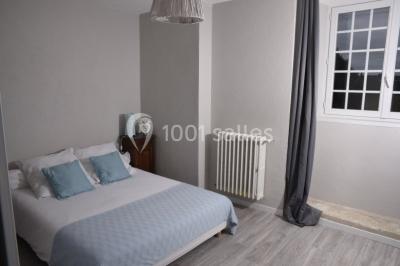 Couronne décorative suspendue sous un plafond en bois, ornée de feuillages, fleurs séchées et éléments naturels.