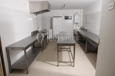 Couronne décorative suspendue sous un plafond en bois, ornée de feuillages, fleurs séchées et éléments naturels.