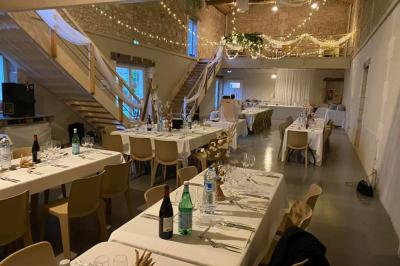 Couronne décorative suspendue sous un plafond en bois, ornée de feuillages, fleurs séchées et éléments naturels.