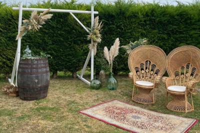 Couronne décorative suspendue sous un plafond en bois, ornée de feuillages, fleurs séchées et éléments naturels.