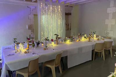 Couronne décorative suspendue sous un plafond en bois, ornée de feuillages, fleurs séchées et éléments naturels.