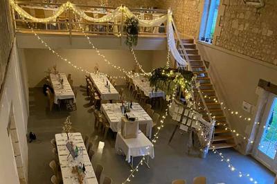 Couronne décorative suspendue sous un plafond en bois, ornée de feuillages, fleurs séchées et éléments naturels.