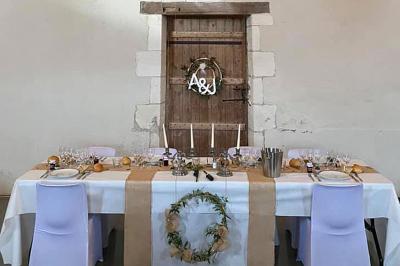 Couronne décorative suspendue sous un plafond en bois, ornée de feuillages, fleurs séchées et éléments naturels.