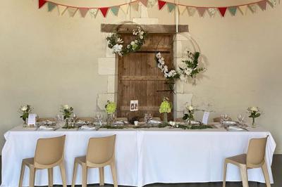 Couronne décorative suspendue sous un plafond en bois, ornée de feuillages, fleurs séchées et éléments naturels.
