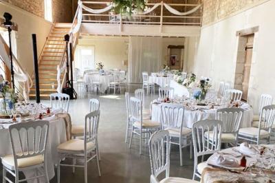 Couronne décorative suspendue sous un plafond en bois, ornée de feuillages, fleurs séchées et éléments naturels.