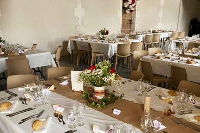 Couronne décorative suspendue sous un plafond en bois, ornée de feuillages, fleurs séchées et éléments naturels.