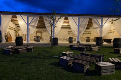 Couronne décorative suspendue sous un plafond en bois, ornée de feuillages, fleurs séchées et éléments naturels.