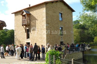 Vélo ancien garé devant une structure en bois et métal avec des toiles blanches tendues, entourée de verdure.