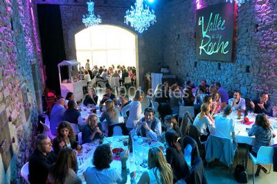Vélo ancien garé devant une structure en bois et métal avec des toiles blanches tendues, entourée de verdure.