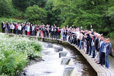 Vélo ancien garé devant une structure en bois et métal avec des toiles blanches tendues, entourée de verdure.