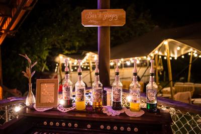 Vélo ancien garé devant une structure en bois et métal avec des toiles blanches tendues, entourée de verdure.