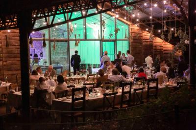 Vélo ancien garé devant une structure en bois et métal avec des toiles blanches tendues, entourée de verdure.