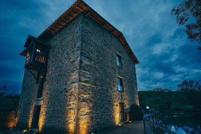Vélo ancien garé devant une structure en bois et métal avec des toiles blanches tendues, entourée de verdure.