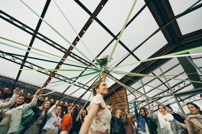 Vélo ancien garé devant une structure en bois et métal avec des toiles blanches tendues, entourée de verdure.