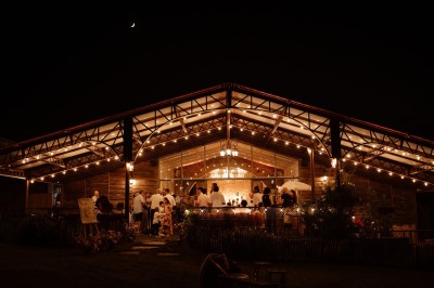 Ancien moulin en pierre avec une grande roue à aubes, bordé par un cours d'eau et entouré de végétation.