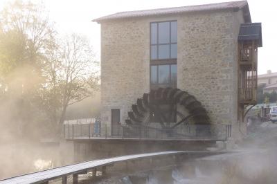 Salle de réception éclairée en rose avec un buffet dressé et des tables hautes décorées de petites lampes.