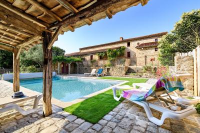 Salle de réception éclairée en rose avec un buffet dressé et des tables hautes décorées de petites lampes.