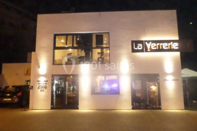 Des personnes se servent à un buffet varié disposé sur des tables rondes dans une salle lumineuse.