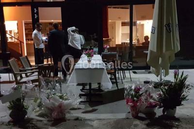 Des personnes se servent à un buffet varié disposé sur des tables rondes dans une salle lumineuse.