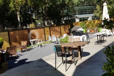 Des personnes se servent à un buffet varié disposé sur des tables rondes dans une salle lumineuse.
