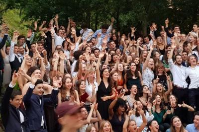 Des personnes se servent à un buffet varié disposé sur des tables rondes dans une salle lumineuse.
