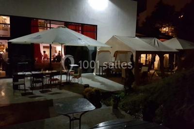 Buffet avec des plats variés, dont des salades, du saumon fumé et des fruits, décoré d'un bouquet de fleurs violettes et…