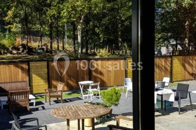 Buffet avec des plats variés, dont des salades, du saumon fumé et des fruits, décoré d'un bouquet de fleurs violettes et…