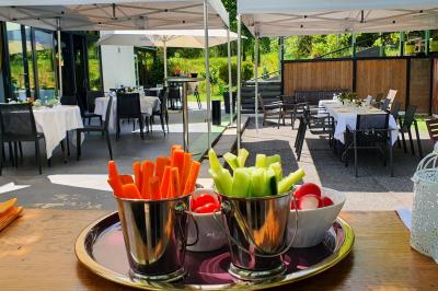 Buffet avec des plats variés, dont des salades, du saumon fumé et des fruits, décoré d'un bouquet de fleurs violettes et…
