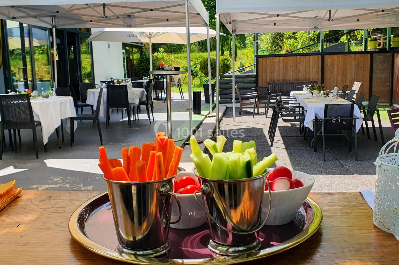 Plateau de légumes frais, dont carottes, concombres et radis, présenté dans des seaux métalliques sur une terrasse…
