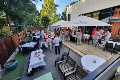 Buffet avec des plats variés, dont des salades, du saumon fumé et des fruits, décoré d'un bouquet de fleurs violettes et…
