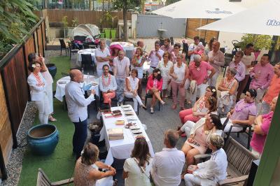 Buffet avec des plats variés, dont des salades, du saumon fumé et des fruits, décoré d'un bouquet de fleurs violettes et…