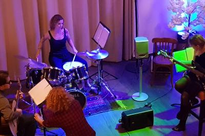 Buffet avec des plats variés, dont des salades, du saumon fumé et des fruits, décoré d'un bouquet de fleurs violettes et…