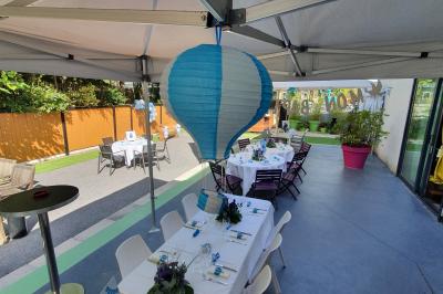 Buffet avec des plats variés, dont des salades, du saumon fumé et des fruits, décoré d'un bouquet de fleurs violettes et…