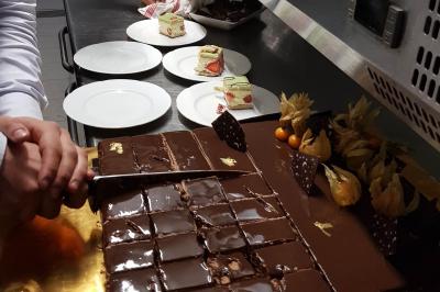 Buffet avec des plats variés, dont des salades, du saumon fumé et des fruits, décoré d'un bouquet de fleurs violettes et…