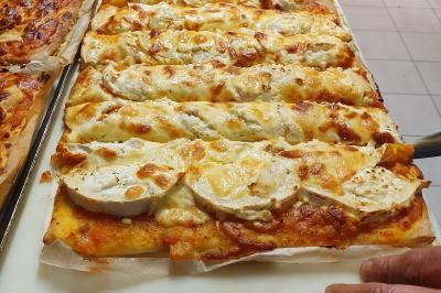 Buffet avec des plats variés, dont des salades, du saumon fumé et des fruits, décoré d'un bouquet de fleurs violettes et…