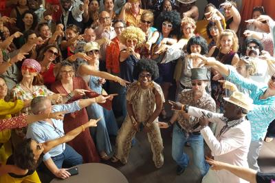 Buffet avec des plats variés, dont des salades, du saumon fumé et des fruits, décoré d'un bouquet de fleurs violettes et…