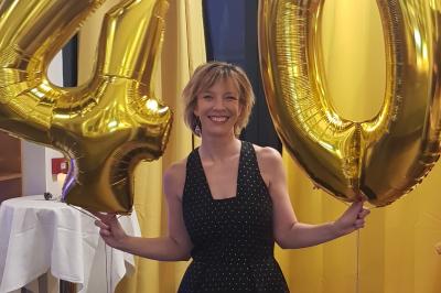 Buffet avec des plats variés, dont des salades, du saumon fumé et des fruits, décoré d'un bouquet de fleurs violettes et…