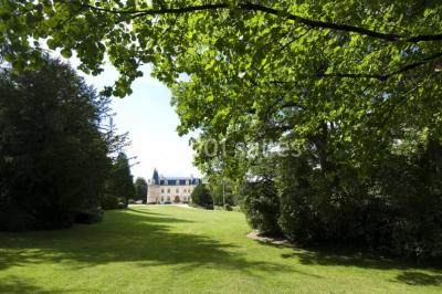 Vue nocturne d'une réception dans une tente éclairée, installée devant un bâtiment de style château.