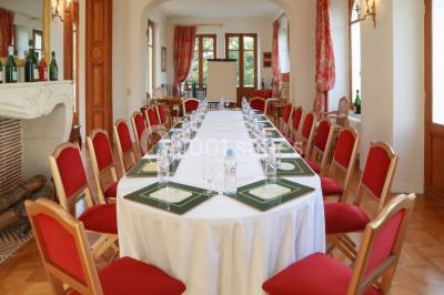 Vue nocturne d'une réception dans une tente éclairée, installée devant un bâtiment de style château.