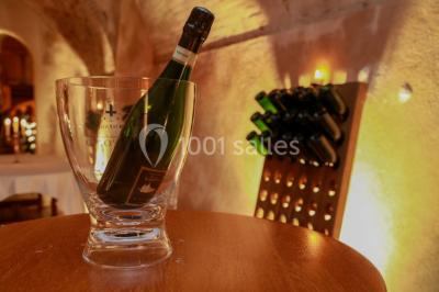 Vue nocturne d'une réception dans une tente éclairée, installée devant un bâtiment de style château.