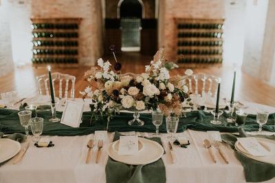 Vue nocturne d'une réception dans une tente éclairée, installée devant un bâtiment de style château.