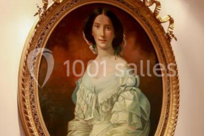 Des bouteilles de vin blanc dans une caisse en bois, avec un bar en bois et des tabourets en arrière-plan.