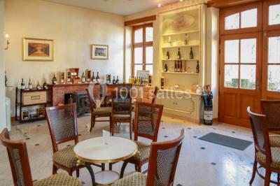 Des bouteilles de vin blanc dans une caisse en bois, avec un bar en bois et des tabourets en arrière-plan.