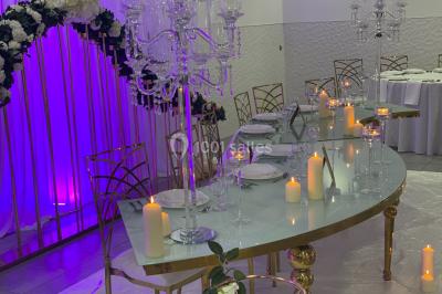 Assiette avec un jarret d'agneau en sauce et un millefeuille de légumes, servie sur une table dressée.