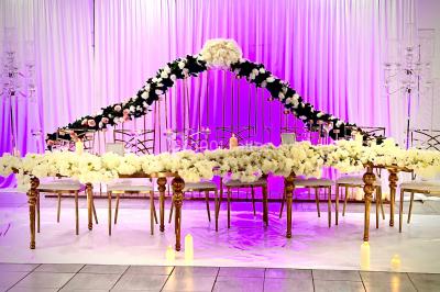 Assiette avec un jarret d'agneau en sauce et un millefeuille de légumes, servie sur une table dressée.
